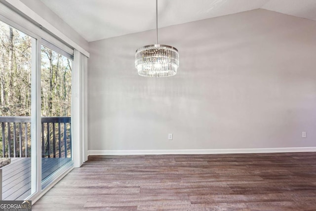 unfurnished dining area featuring wood-type flooring, vaulted ceiling, and an inviting chandelier