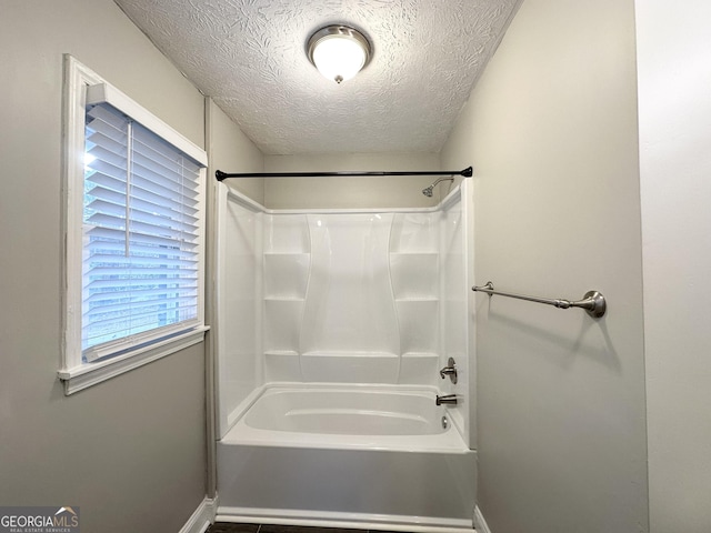 bathroom featuring a textured ceiling and  shower combination