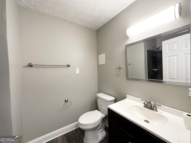 bathroom with vanity, a shower, a textured ceiling, and toilet