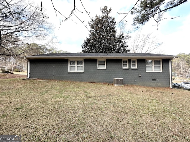 back of property with central air condition unit and a yard