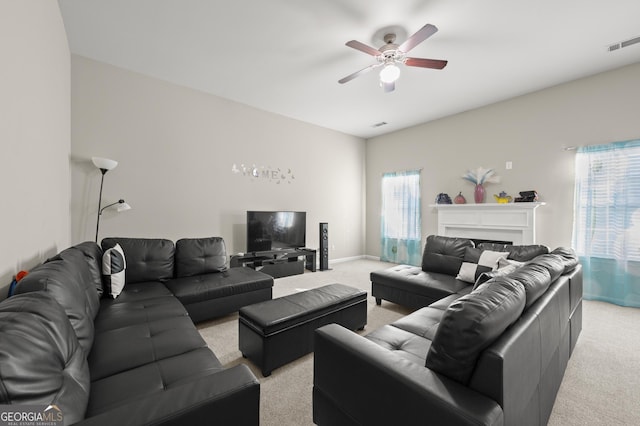 living room featuring ceiling fan, light colored carpet, and a healthy amount of sunlight