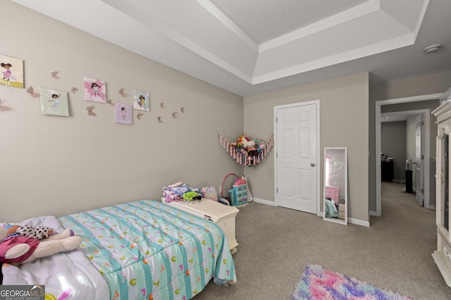 bedroom with a raised ceiling and carpet flooring