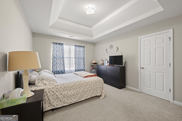 bedroom featuring carpet flooring and a tray ceiling