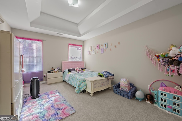 bedroom with carpet floors and a tray ceiling