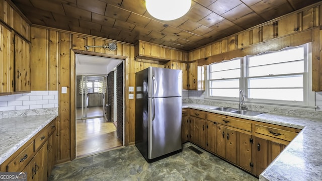 kitchen featuring wooden ceiling, sink, stainless steel refrigerator, and tasteful backsplash