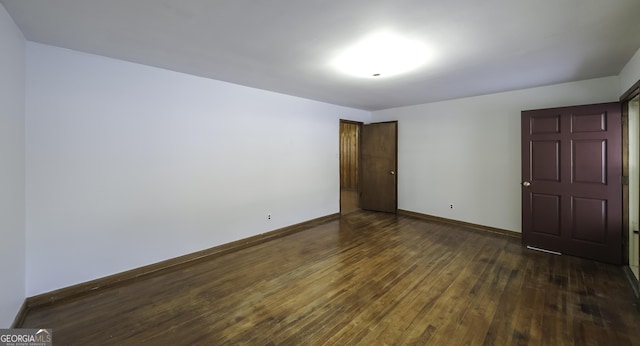 empty room with dark hardwood / wood-style flooring