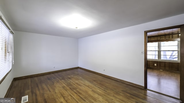 unfurnished room with dark hardwood / wood-style flooring