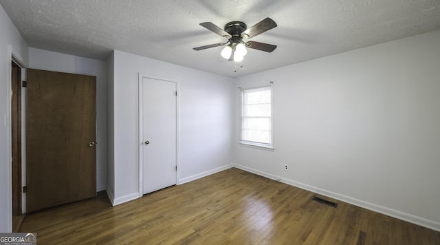 unfurnished bedroom featuring a closet, ceiling fan, hardwood / wood-style floors, and a textured ceiling