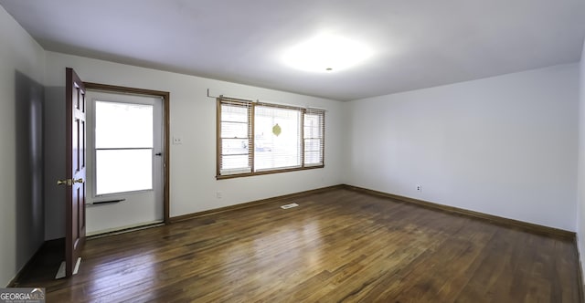 spare room with dark wood-type flooring