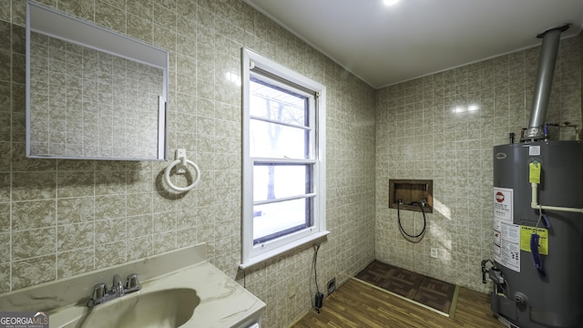 bathroom with water heater, sink, and wood-type flooring