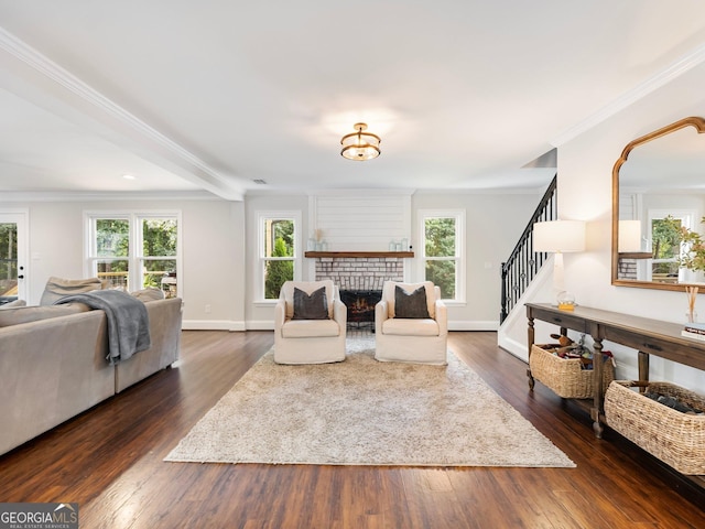 living area with dark wood-type flooring, stairway, a brick fireplace, and a healthy amount of sunlight