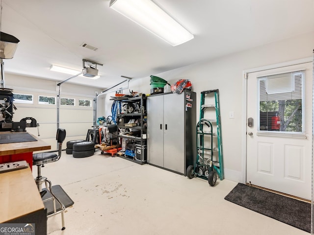 garage with a garage door opener and visible vents