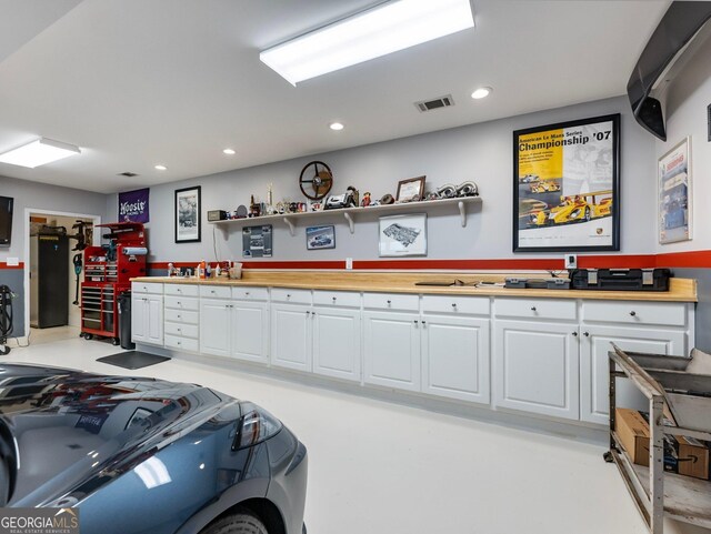 kitchen with a kitchen breakfast bar, butcher block counters, and white cabinets