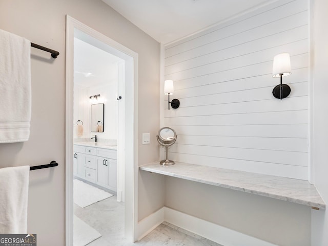 full bathroom featuring marble finish floor, baseboards, and vanity