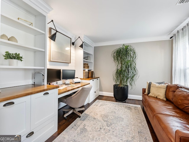 office with ornamental molding, dark wood-type flooring, and built in desk