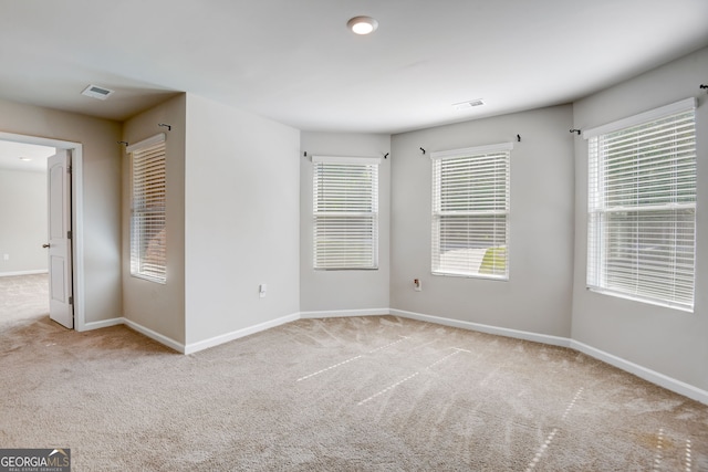 spare room featuring light colored carpet