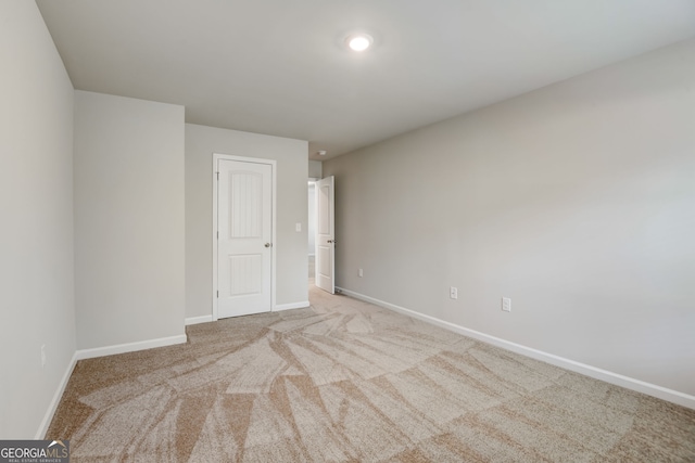 spare room featuring light carpet