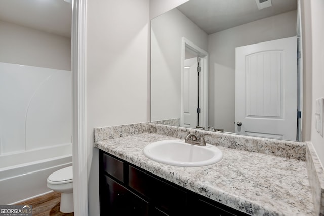 full bathroom featuring vanity, wood-type flooring,  shower combination, and toilet