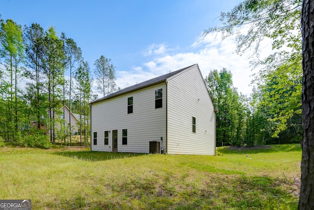 back of house with a lawn and central AC unit