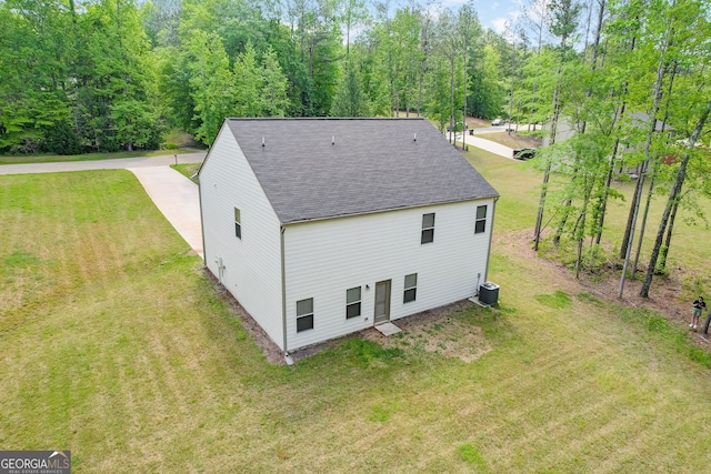 back of house with central AC and a yard