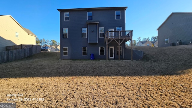 rear view of house featuring a yard and a deck