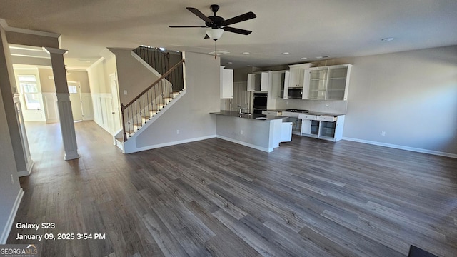 unfurnished living room featuring ceiling fan, sink, and dark wood-type flooring