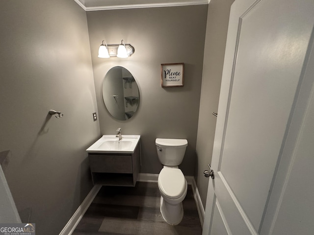 bathroom with toilet, crown molding, and vanity