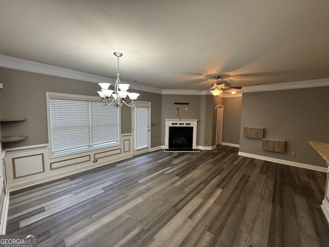 unfurnished living room with dark wood-type flooring, crown molding, and ceiling fan with notable chandelier