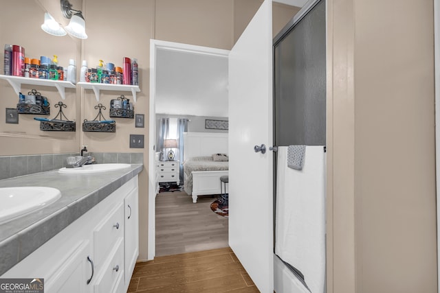 bathroom featuring a shower with door, vanity, and wood-type flooring