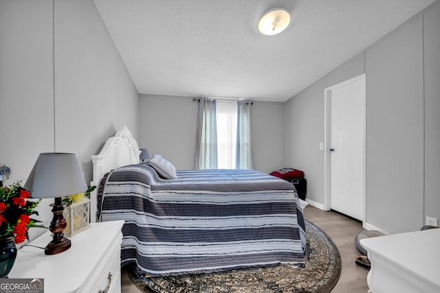 bedroom with a textured ceiling and dark hardwood / wood-style floors