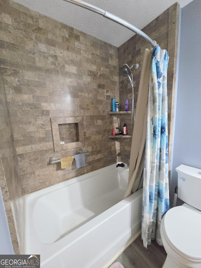 bathroom featuring shower / bath combo with shower curtain, wood-type flooring, a textured ceiling, and toilet