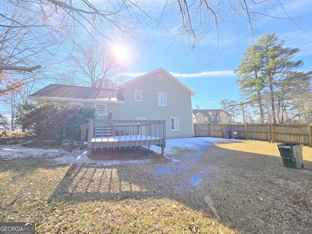 rear view of property with a lawn and a wooden deck