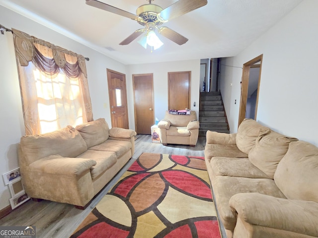 living room featuring hardwood / wood-style floors and ceiling fan