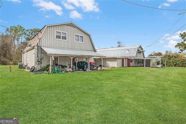 rear view of property featuring a lawn