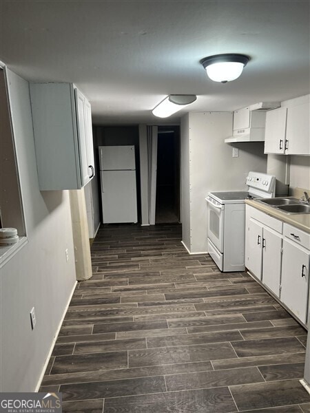 kitchen with sink, white appliances, and white cabinets