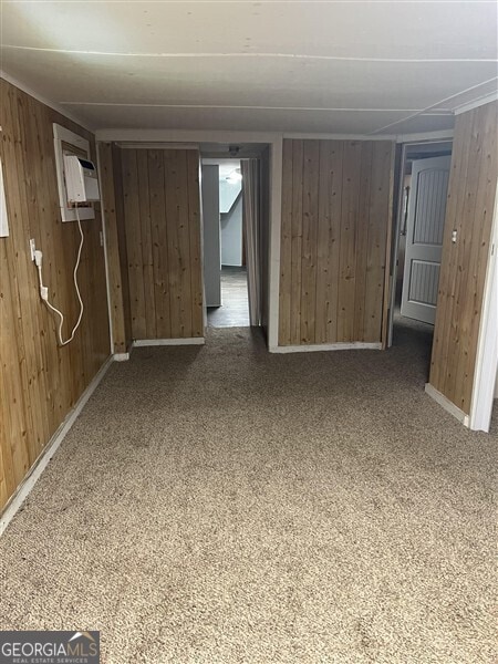 basement featuring wood walls and an AC wall unit