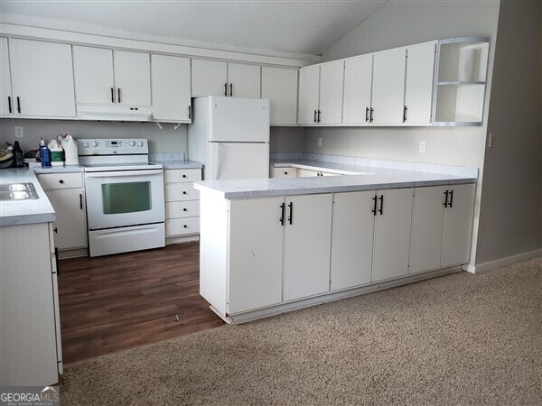 kitchen featuring sink, white cabinetry, lofted ceiling, and white appliances