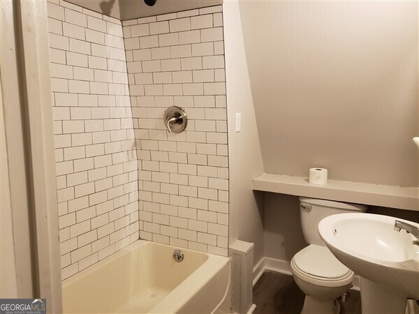 full bathroom with sink, toilet, and tiled shower / bath combo