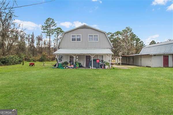 rear view of property featuring a lawn