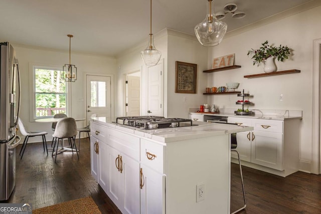 kitchen with light stone countertops, appliances with stainless steel finishes, a center island, and white cabinetry