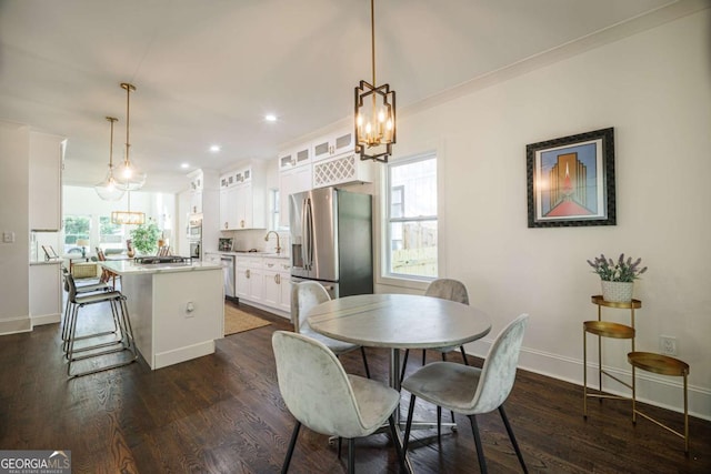 dining area with dark hardwood / wood-style floors, a healthy amount of sunlight, crown molding, and sink