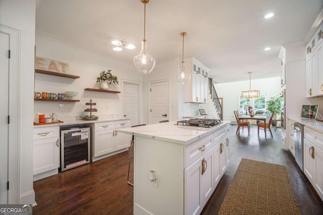 kitchen with light stone countertops, stainless steel appliances, pendant lighting, white cabinets, and wine cooler