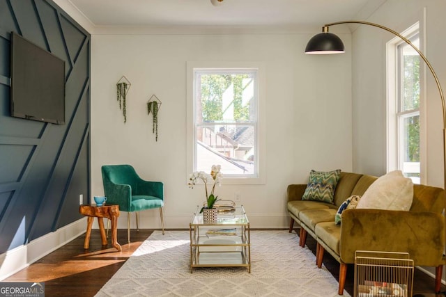 living area featuring crown molding and hardwood / wood-style flooring