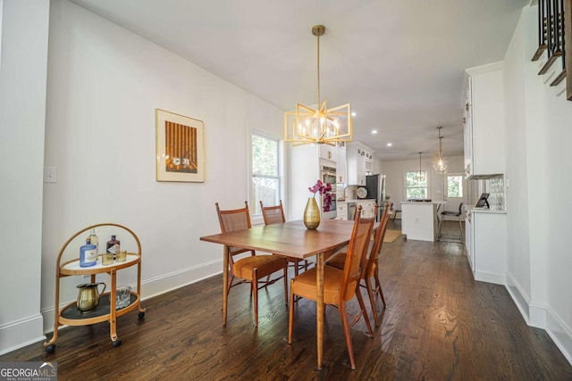 dining room featuring a wealth of natural light, dark wood-type flooring, and an inviting chandelier