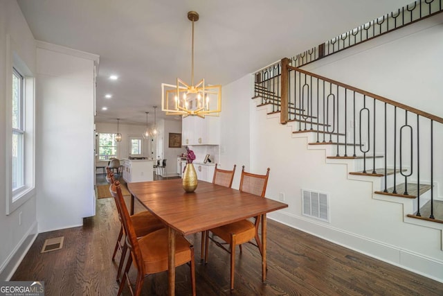 dining space featuring dark hardwood / wood-style flooring and an inviting chandelier