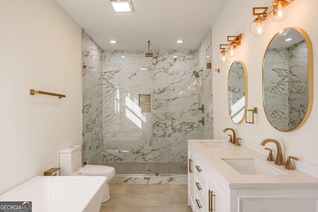 bathroom featuring a tile shower, vanity, and toilet