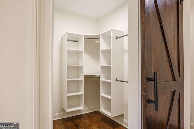 spacious closet with dark wood-type flooring