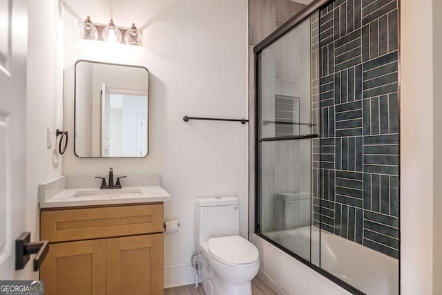 full bathroom with shower / bath combination with glass door, vanity, and toilet