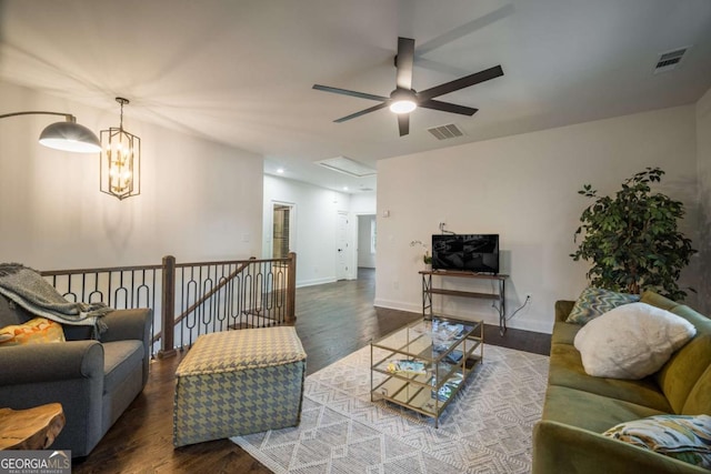 living room featuring ceiling fan with notable chandelier and dark hardwood / wood-style floors