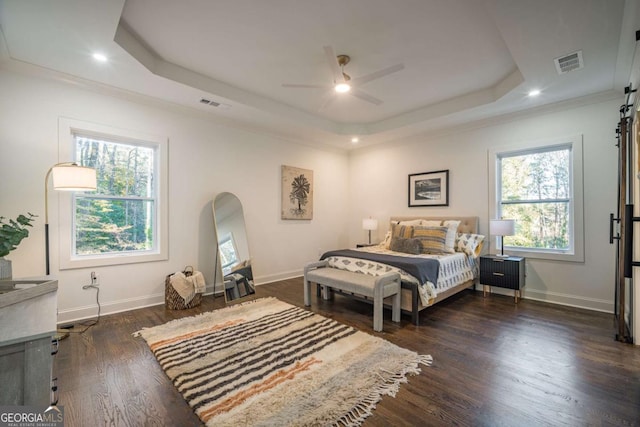 bedroom with a tray ceiling, ceiling fan, crown molding, and dark hardwood / wood-style floors